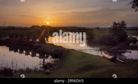 Image d'un canoë sur une rive de la rivière au coucher du soleil à Tangalle, Sri Lanka Banque D'Images