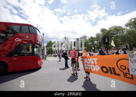 Londres, Royaume-Uni. 24th juin 2023. Des manifestants sont vus tenir une bannière et arrêter la traite à Westminster pendant leur marche lente. Les manifestants du groupe d’activistes pour le climat, Just Stop Oil (JSO), continuent de ralentir la marche dans le centre de Londres pour protester contre le développement et l’utilisation de combustibles fossiles qui ont un impact considérable sur le climat actuel. Crédit : SOPA Images Limited/Alamy Live News Banque D'Images