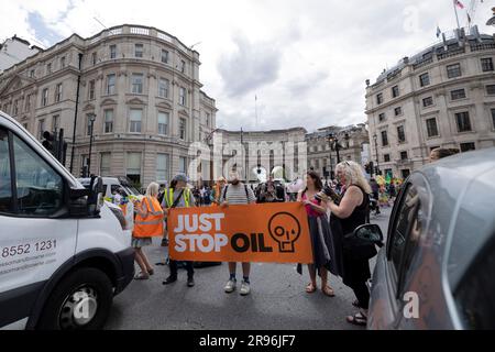 Londres, Royaume-Uni. 24th juin 2023. Les manifestants tiennent une bannière et arrêtent la traite à Trafalgar Square pendant leur marche lente. Les manifestants du groupe d’activistes pour le climat, Just Stop Oil (JSO), continuent de ralentir la marche dans le centre de Londres pour protester contre le développement et l’utilisation de combustibles fossiles qui ont un impact considérable sur le climat actuel. (Photo de Hesther ng/SOPA Images/Sipa USA) crédit: SIPA USA/Alay Live News Banque D'Images