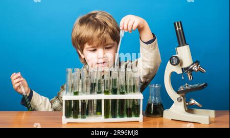 Expérience éducative. Garçon avec tubes à essai et microscope dans la classe scolaire. Journée des connaissances. Étude de l'enfant biologie chimie. Sciences, éducation et Banque D'Images