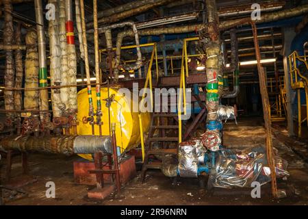 Vieux fer en métal rouillé abandonné mauvais dans les équipements de corrosion échangeurs de chaleur tuyaux pompes dans un atelier de raffinerie industrielle de l'usine pétrochimique. Banque D'Images