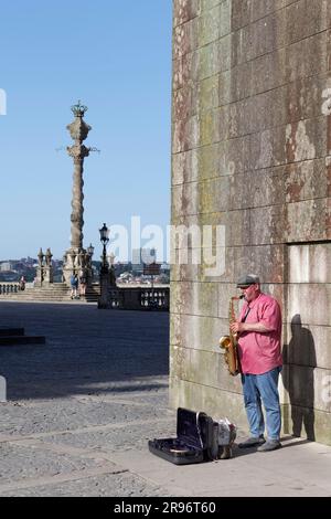 Musicien de rue jouant des saxophones devant la cathédrale se do Porto, colonne Pelourinho, pilori, Porto, Portugal Banque D'Images