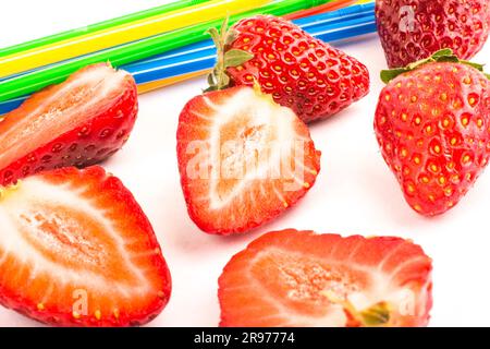 Pailles de fraise et de couleur éparpillées sur fond blanc Banque D'Images