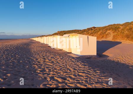 Cabines de plage au coucher du soleil le long de la mer du Nord, Belgique. Banque D'Images