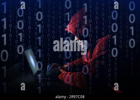 Cyber-attaque. Pirate anonyme travaillant avec un ordinateur portable sur fond bleu foncé. Code binaire autour de lui Banque D'Images