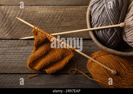 Fils doux colorés, tricotage et aiguilles sur table en bois, vue du dessus Banque D'Images