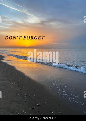 N'oubliez pas, affirmation. Vagues de mer se déroulant sur une plage de sable au lever du soleil Banque D'Images