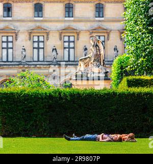 FRANCE. PARIS (75) LE MUSÉE DU LOUVRE. JARDINS DU CARROUSEL. UN COUPLE ALLONGÉ SUR UNE PELOUSE Banque D'Images