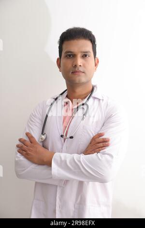Médecin femme senior en blouse de laboratoire avec les bras croisés sur fond blanc. Heureux docteur indien en manteau blanc. confiant. Banque D'Images