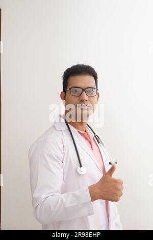 Médecin femme senior en blouse de laboratoire avec les bras croisés sur fond blanc. Heureux docteur indien en manteau blanc. confiant. Banque D'Images