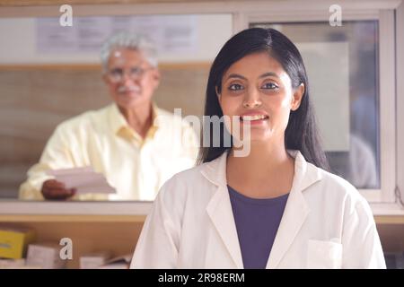 chimiste homme debout dans la pharmacie - pharmacie. Gros plan sur le pharmacien à la pharmacie hospitalière. Assistance aux clients, client âgé senior au comptoir. Banque D'Images
