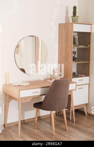 intérieur moderne de la chambre, coiffeuse avec miroir et fauteuil rembourré. décor tendance de style minimaliste. tir vertical Banque D'Images
