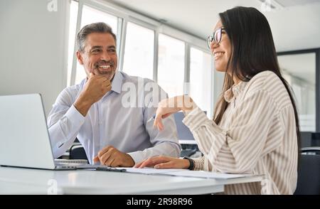 Heureux divers cadres professionnels travaillant au bureau et parlant. Banque D'Images