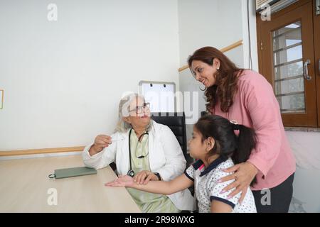 médecin de visite de famille heureuse pour consultation personnelle avec leur fille, fille à l'hôpital, check up, cabine, bureau, conscient de la santé, attention. Banque D'Images