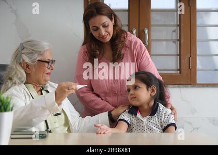 médecin de visite de famille heureuse pour consultation personnelle avec leur fille, fille à l'hôpital, check up, cabine, bureau, conscient de la santé, attention. Banque D'Images