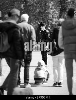 Un agent officiel de l'application de la loi veille sur un enfant dans un coin de rue urbain Banque D'Images