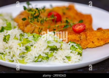 Plat à la décoration chic, poulet pané au brocoli et riz au thym. la vraie cuisine Banque D'Images