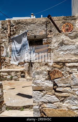 Maison de village traditionnelle dans une rue reculée d'Apollonas, un village de pêcheurs, sur Naxos. Marche pendante pour sécher et un vieux satellite rouillé. Banque D'Images