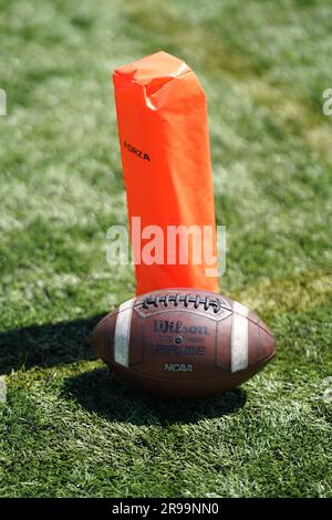 Ballons de football américain Wilson à côté d'un Orange Corner Pylon sur un gazon artificiel Banque D'Images