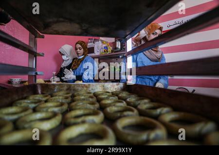 Les femmes palestiniennes font des biscuits appelés « gâteaux d'Eid » avant Eid Al-Adha, dans leur maison de la bande de Gaza, sur 25 juin 2023. Banque D'Images