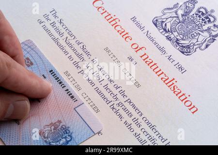 Le permis de résidence biométrique (ILR) est placé au-dessus du certificat de naturalisation en tant que citoyen britannique. Stafford, Royaume-Uni, 25 juin 2023 Banque D'Images