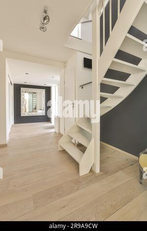 une maison avec parquet et escalier blanc menant au deuxième étage, qui est peint en bleu foncé Banque D'Images