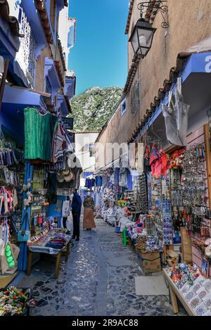 Les montagnes du Riff s'élèvent à travers un petit bazar de rue, dans la ville bleue de Chefchaouen, au Maroc Banque D'Images