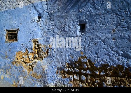 Un ancien mur, se détériorant, mais ressuscité avec de la peinture bleue à Chefchaouen, au Maroc Banque D'Images