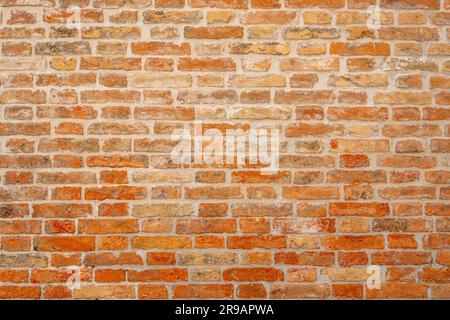 Arrière-plan d'un vieux mur de briques orange usé Banque D'Images