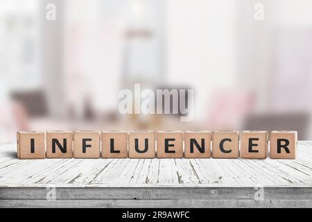 Influenceur signe sur une table en bois dans une pièce très lumineuse, d'un blogueur Banque D'Images