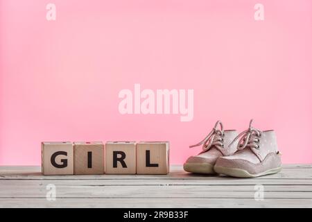 Chaussures bébé fille en rose sur une table en bois Banque D'Images