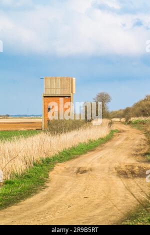 Petite maison faite de briques par une route de campagne Banque D'Images