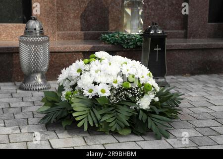 Couronne funéraire de fleurs et de lanternes près de la tombe à l'extérieur Banque D'Images