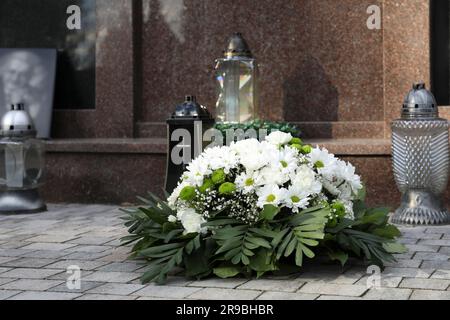 Couronne funéraire de fleurs et de lanternes près de la tombe à l'extérieur Banque D'Images