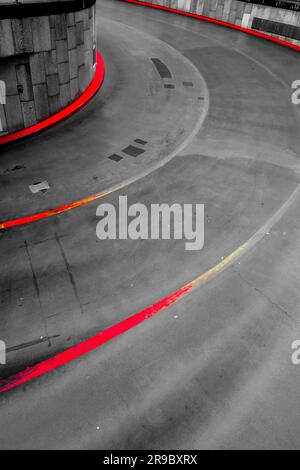 Entrée courbée du parking en asphalte avec bandes rouges Banque D'Images