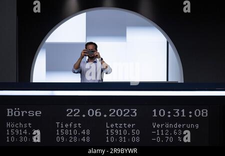 PRODUCTION - 22 juin 2023, Hesse, Francfort-sur-le-main : un homme se trouve au-dessus du tableau indicateur Dax dans la salle de négociation de Deutsche Börse. L'indice de référence allemand DAX existe depuis 35 ans sur 1 juillet. Photo : Boris Roessler/dpa Banque D'Images
