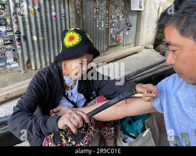 Buscalan, Philippines. 24th mai 2023. Maria Oggay, populairement connu sous le nom d'Apo Whang-OD, le plus vieux mambabatok ou tatoueur traditionnel aux Philippines, tatouent un bras d'homme en utilisant des techniques traditionnelles. À 106 ans, Whang-OD pratique encore l'art antique du batok - la technique de tatouage à la main en utilisant une épine de citron et de la suie de charbon qu'elle a appris comme une adolescente. (À dpa 'Tattoo art à 106 ans: Visite de Vogue Cover Girl Whang-OD') Credit: Girlie Linao/dpa/Alay Live News Banque D'Images