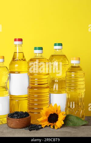 Bouteilles d'huile de cuisson, de tournesol et de graines sur table en bois Banque D'Images