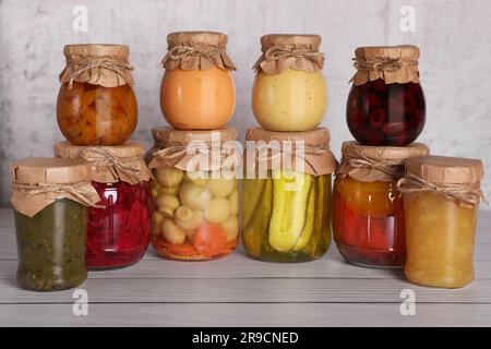 Beaucoup de pots en verre avec différents produits conservés sur table en bois Banque D'Images
