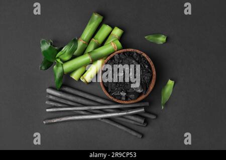 Bambou frais et charbon de bois sur fond noir, plat Banque D'Images