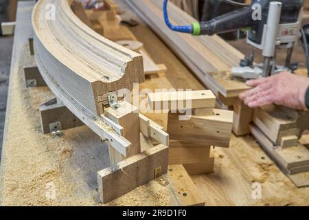 Rambarde d'escalier en bois cintrage en planches de chêne et en contreplaqué sur la clôture de la table. Détail de la clôture des escaliers dans l'atelier de menuiserie Banque D'Images