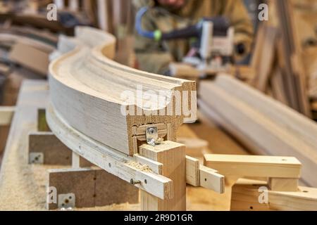 Rambarde d'escalier en bois cintrage en planches de chêne et en contreplaqué sur la clôture de la table. Détail de la clôture des escaliers dans l'atelier de menuiserie Banque D'Images