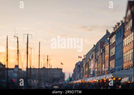 Oiseau survolant la rue colorée de Nyhavn au coucher du soleil Banque D'Images