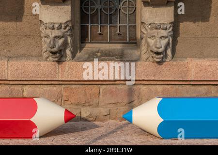 Deux bancs amusants en forme de crayon bleu et rouge dans le centre historique de Porto Ceresio, Italie Banque D'Images