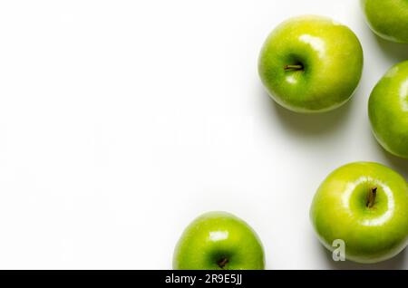 Pommes vertes sur fond blanc avec espace de copie. Banque D'Images