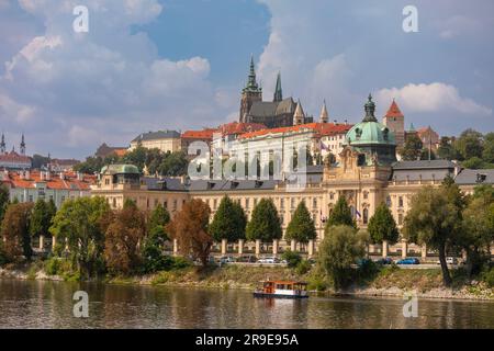 PRAGUE, RÉPUBLIQUE TCHÈQUE, EUROPE - Bâtiment de l'Académie Straka, bureau du Gouvernement de la République tchèque, sur la Vltava. Prague Castl se trouve en haut à gauche Banque D'Images