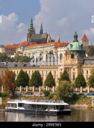 PRAGUE, RÉPUBLIQUE TCHÈQUE, EUROPE - une croisière en bateau sur la Vltava passe devant le bâtiment de l'Académie Straka, le bureau du gouvernement de la République tchèque. Au-dessus du Banque D'Images