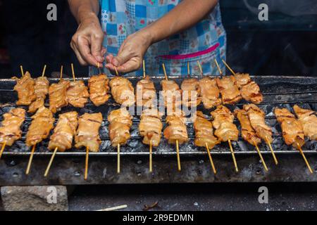 moo ping, bâtonnets de brochette de porc grillé sur le barbecue en plein air, cuisine thaïlandaise de rue Banque D'Images