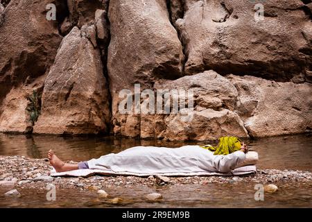 Personne vêtue, près de la rivière de montagne. « Gorges du Dades » Maroc. Assis dans l'ombre de la pluie de l'Atlas central, les 'Gorges du Dades' prese Banque D'Images