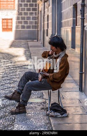 Grenade, Espagne - 22 février 2022: Jeune guitariste dans les rues de Grenade, Espagne. Banque D'Images